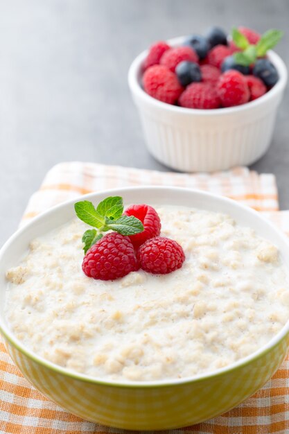 Oatmeal porridge in bowl with berries raspberries and blackberries.