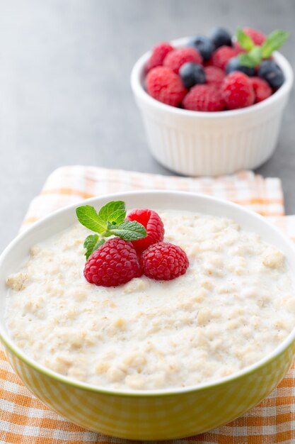 Porridge di farina d'avena in una ciotola con lamponi e more.