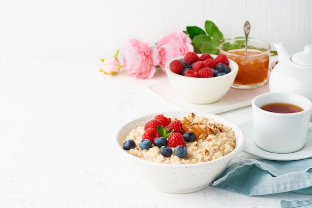 Oatmeal porridge with blueberry, raspberries, jam and nuts