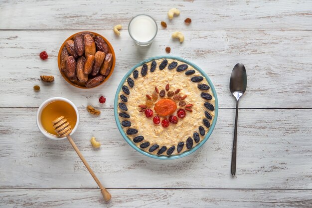 Oatmeal porridge with dried fruits on a wooden table. Top view.