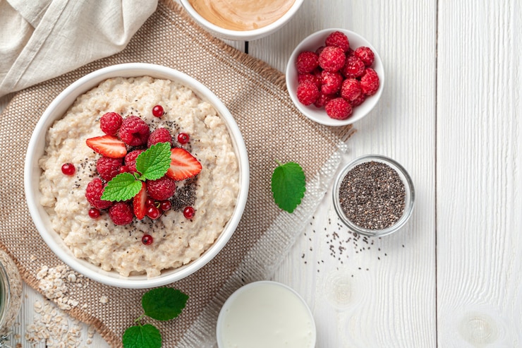 Photo oatmeal porridge with fresh berries chia seeds and mint on a light background