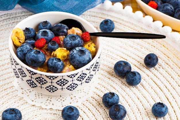 Oatmeal porridge with fresh blueberries, raspberries. fitness breakfast. crunches.