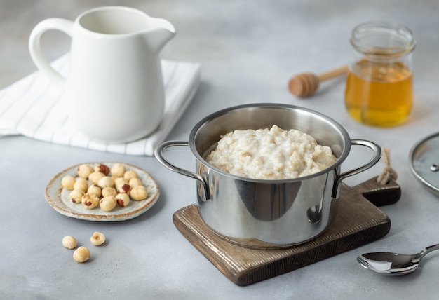 Oatmeal porridge with hazelnuts and cinnamon in a pan