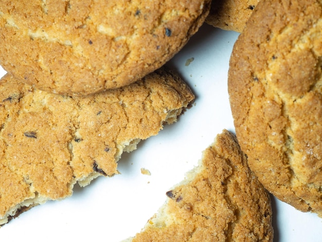 Foto biscotti di farina d'avena e uvetta su sfondo bianco dolci biscotti di tè rotti