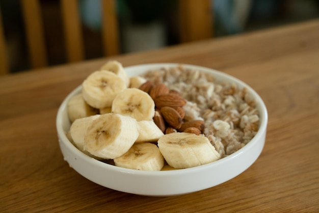 テーブルの上の朝食にバナナ蜂蜜とアーモンドのオートミール