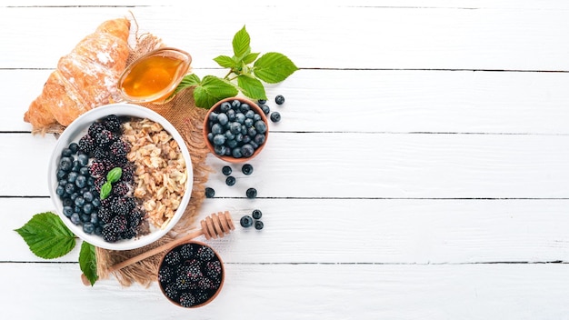 Oatmeal with blueberries and blackberry On a wooden background Top view Free space for text