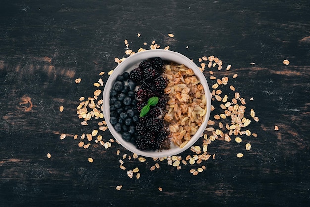 Oatmeal with blueberries and blackberry On a wooden background Top view Free space for text