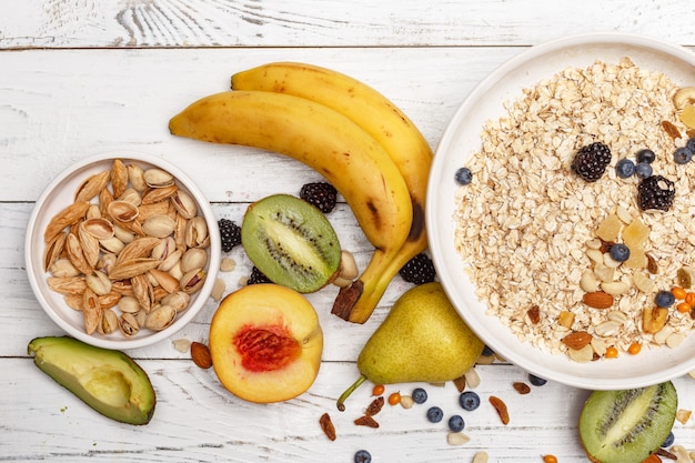 Oatmeal with fruit and honey on a white wooden table