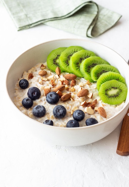 Oatmeal with kiwi blueberries almonds and honey Healthy food Vegetarian food Breakfast