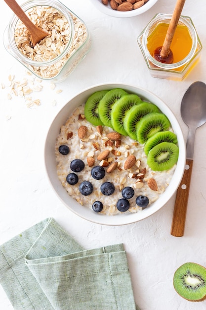 Oatmeal with kiwi blueberries almonds and honey Healthy food Vegetarian food Breakfast