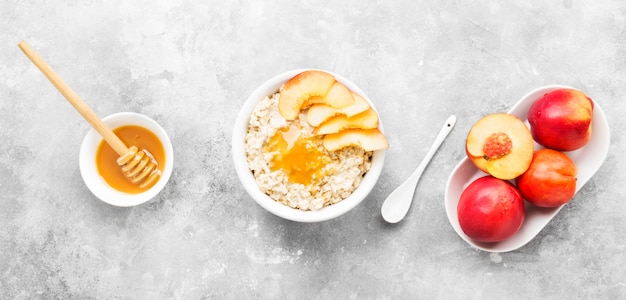 Oatmeal with nectarine and honey on a gray background. Top view. Food background