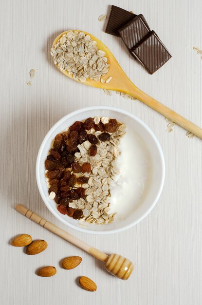 Oatmeal with raisins and yogurt. Oatmeal in the wooden spoon.