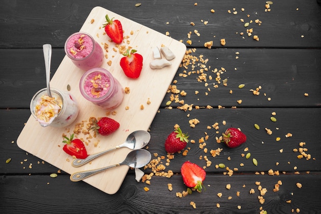 Oatmeal with yogurt and berries on a black wooden background. Top view. Healthy breakfast. 