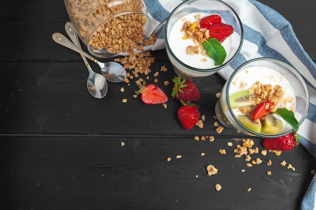 Oatmeal with yogurt and berries on a black wooden surface , Top view, Healthy breakfast, 