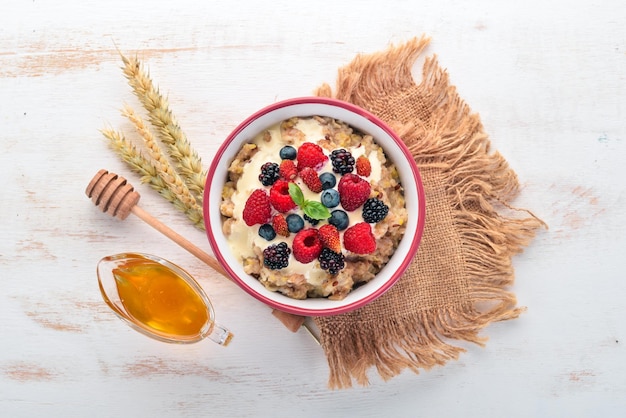 Oatmeal with yogurt and berries Healthy food On a wooden background Top view Free space for text