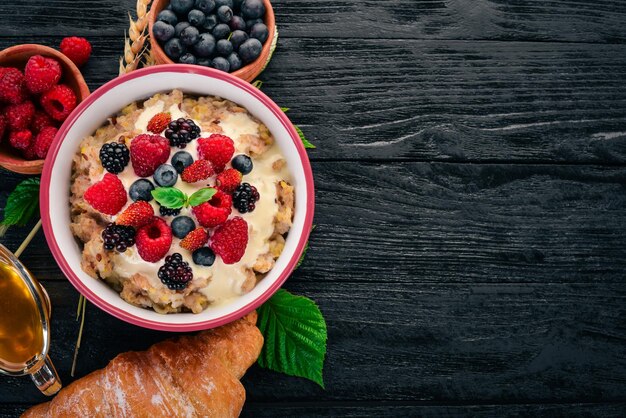 Oatmeal with yogurt and berries Healthy food On a wooden background Top view Free space for text