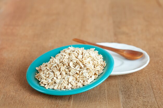 Oats flakes in dish on wood table