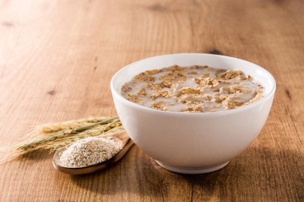 Oats milk and cereals in bowl on wooden table