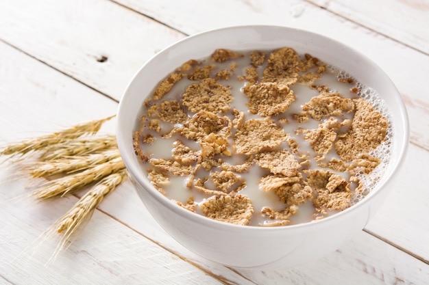 Oats milk and cereals on white wooden table