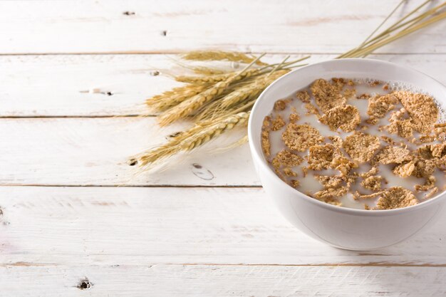 Oats milk and cereals on white wooden table