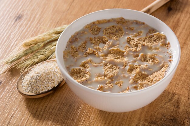 Oats milk and cereals on wooden table