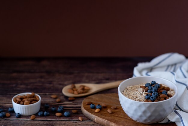 Oats in a spoon in a plate on a table scattered oat flakes