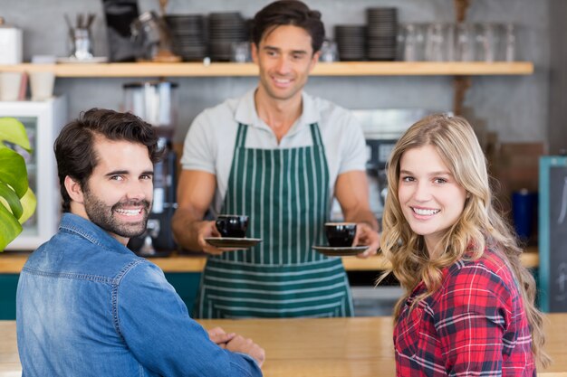 Ober biedt koffie aan een stel