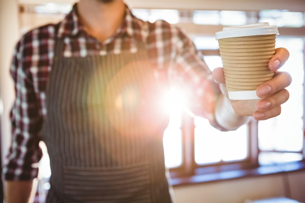 Ober die een koffie overhandigt