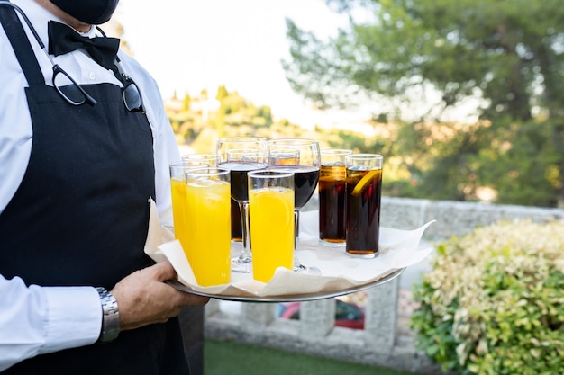 Ober dragende dienblad met glazen met frisdrank