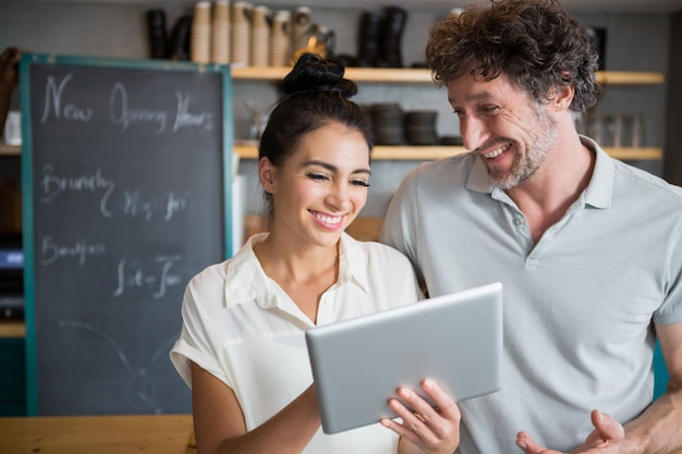 Ober en serveerster bespreken over digitale tablet