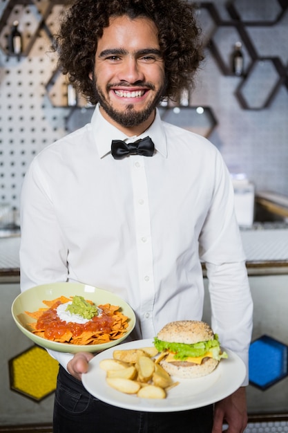 Ober houden platen van snacks en hamburger in bar