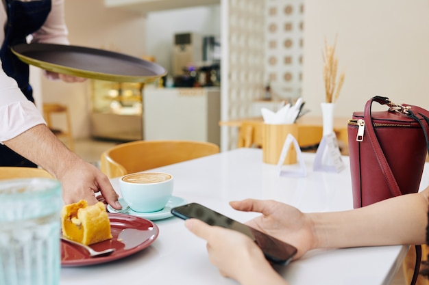 Ober serveert koffie en dessert