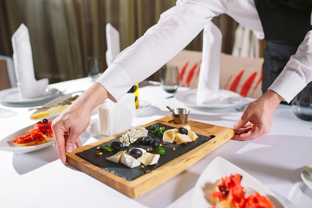 Ober serveertafel in het restaurant bereidt zich voor om gasten te ontvangen.