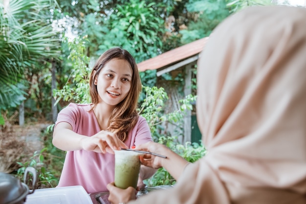 Obers geeft het drankje aan de vrouw die ze heeft besteld