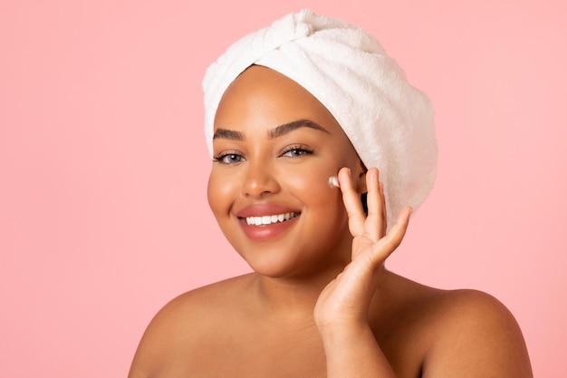 Obese African American Female Applying Cream Moisturizing Face Pink Background