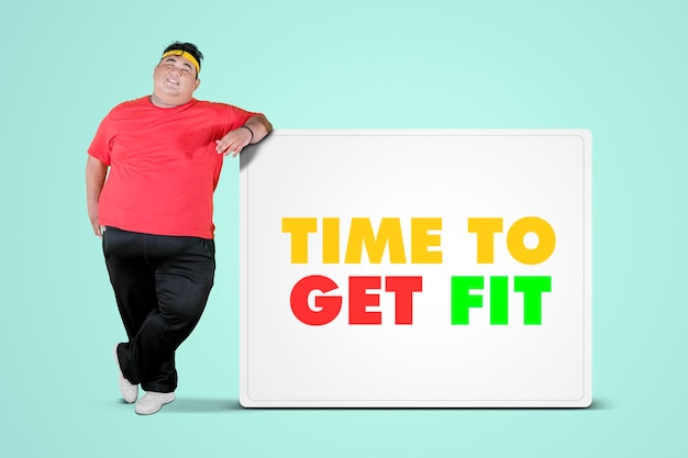 Фото Тучный мужчина опирается на текст time to get fit