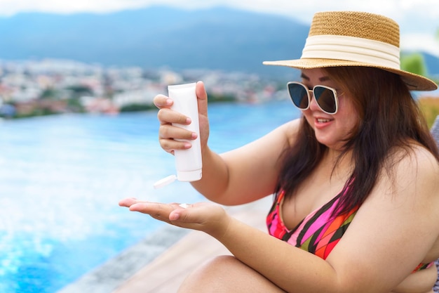 Obese Woman applying sunscreen cream Vacation Traveling with Body Sun protection suncream in hotel resort holiday