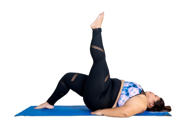 Obese woman lifting her leg during yoga exercises