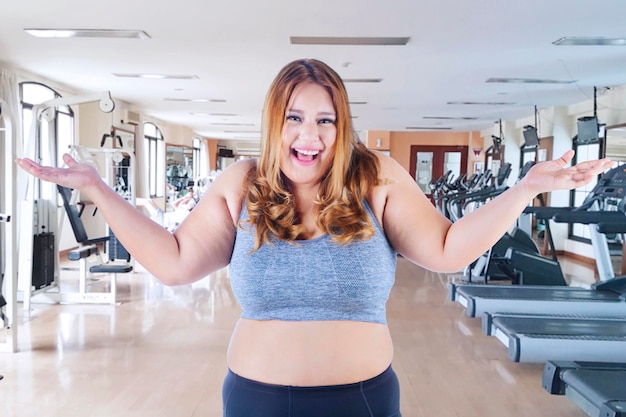 Obese woman looks happy at gym center