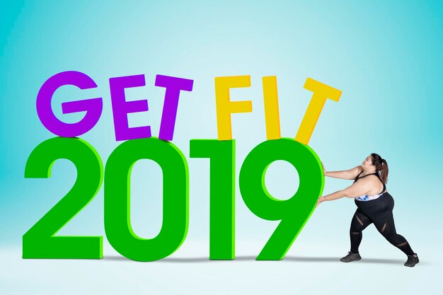 Photo obese woman pushing text of get fit in 2019