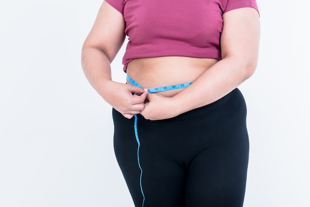 Obese woman use a tape measure Fasten her belly fat