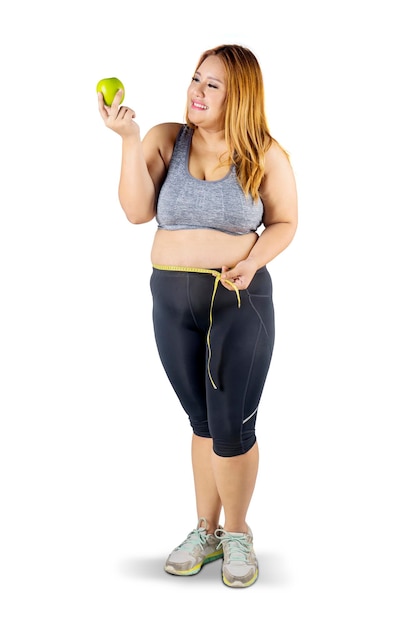 Obese woman with apple fruit and measuring tape