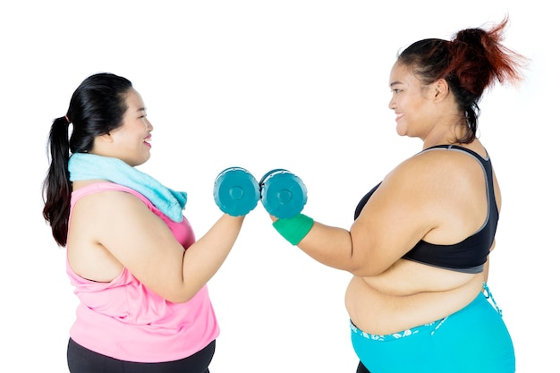 Obese women doing exercise together with dumbbells