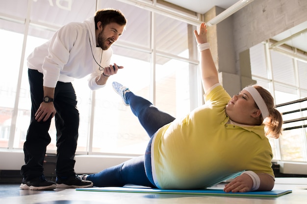 Obese Young Woman Working Out with Coach