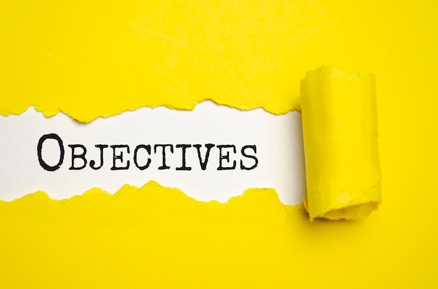 OBJECTIVES text written under torn paper High quality photo