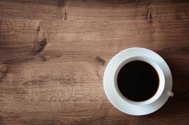 Objects on a wooden table a cup of coffee and a book