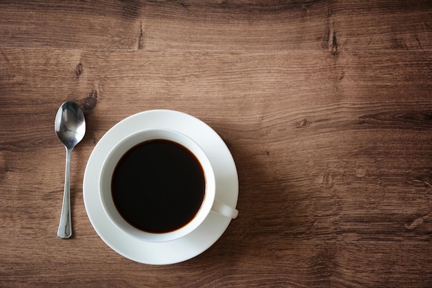 Objects on a wooden table a cup of coffee and a book