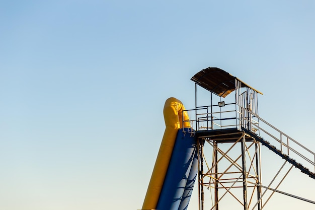 Foto osservazione torre di legno con una barca bagnino sulla spiaggia contro il cielo blu