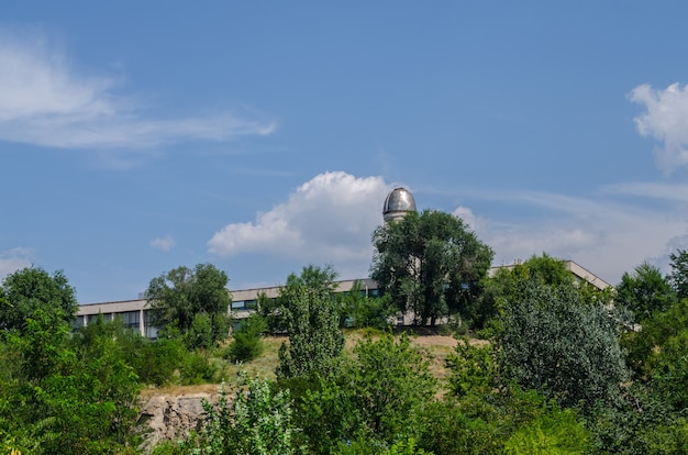 Observatorium op de achtergrond van blauwe lucht met bomen