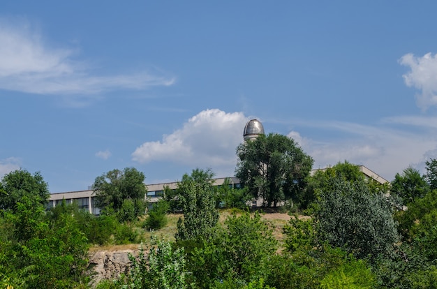 Обсерватория на фоне голубого неба с деревьями